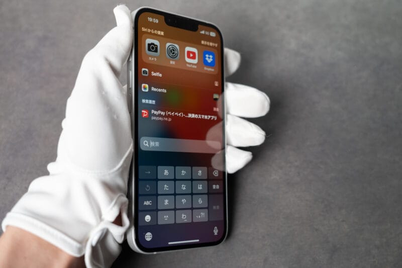 iPhone16eを片手で持った写真
